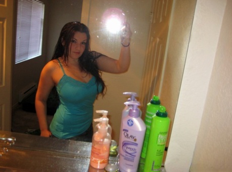 Amatør-solopige tager selvbilleder af sine store bryster i et badeværelsesspejl