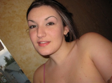 Une fille amateur prend des selfies dans un miroir en montrant ses gros seins.