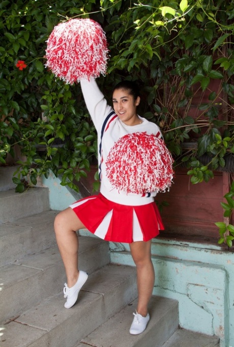 Sexy latinamerikansk cheerleader stripper utendørs for å vise frem hårete armhuler og fitte