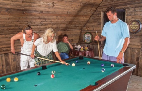 La blonde aux yeux bleus Monika Bella baise deux mecs sur une table de billard