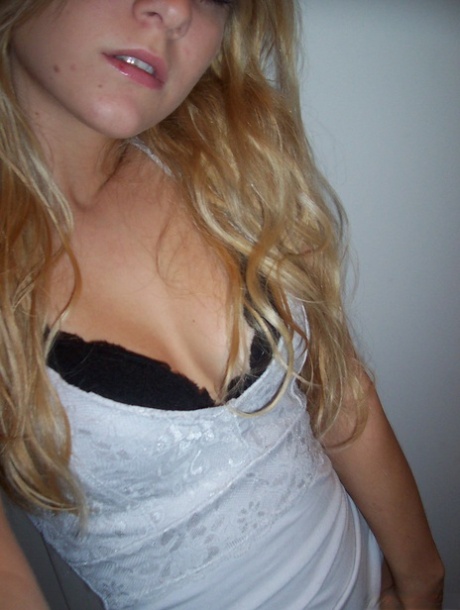 Kylie, une amatrice blonde, prend des selfies dans le miroir en se déshabillant avec son soutien-gorge et son string.
