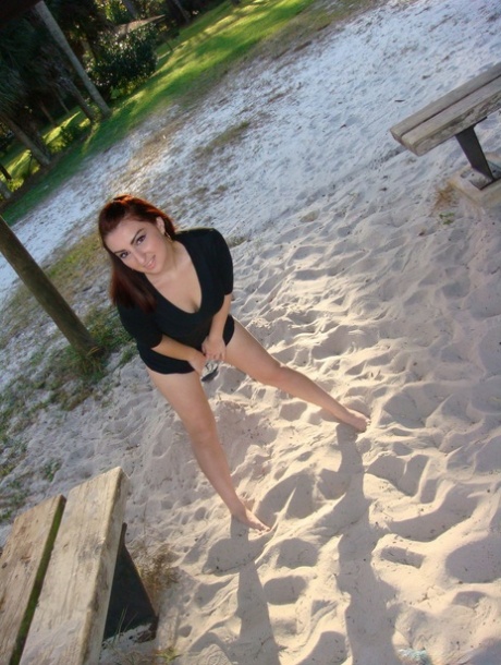 La rossa amatoriale Evie mostra la sua biancheria intima a piedi nudi su una lingua di sabbia