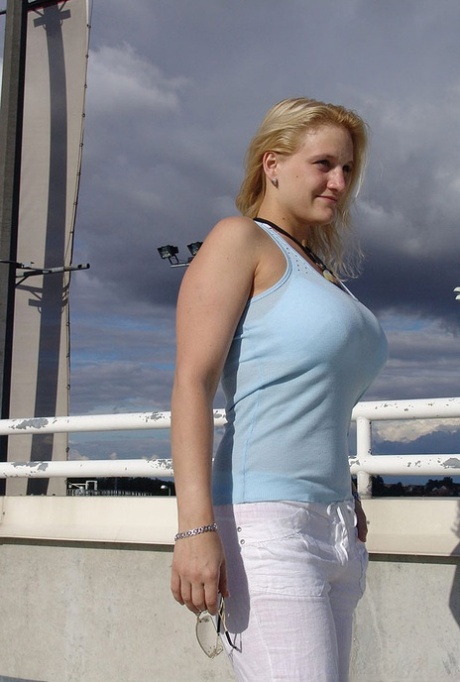Blond solomeisje laat haar grote borsten los in een openbare omgeving