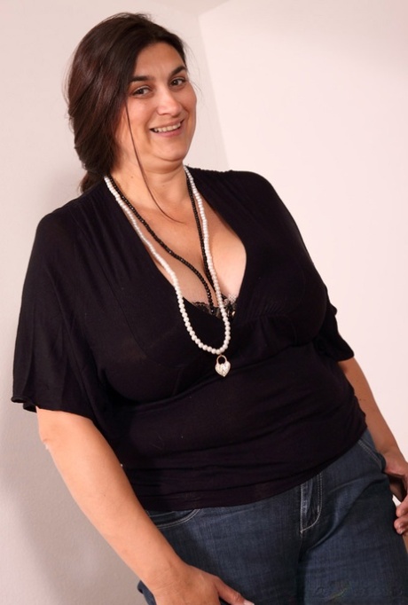 Mulher com excesso de peso liberta as suas enormes mamas enquanto está num sofá