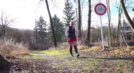 Chubby blonde Licky Lex takes a piss on a path in black boots