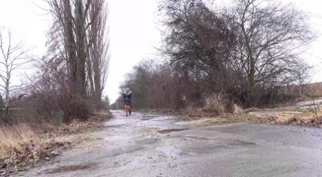 La blonde platine Claudia Macc pisse sur une route pavée à la campagne.