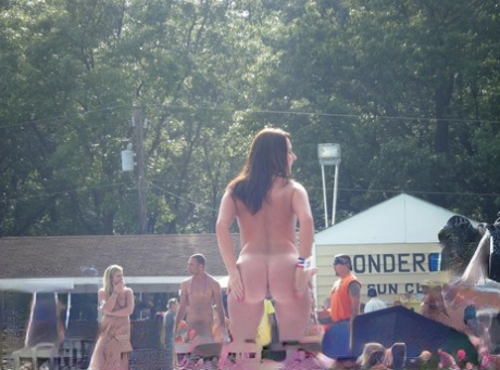 Brunette stripper stapt naakt op een podium in een kleding optionele club