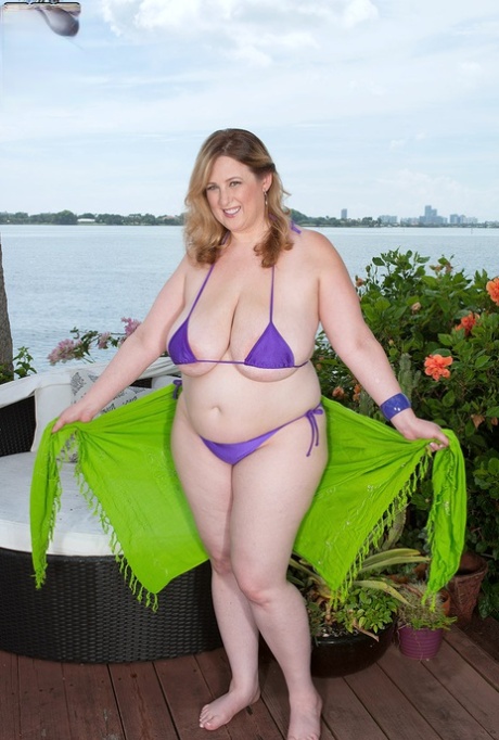 BBW Amiee Roberts solta as suas enormes mamas de um biquíni num pátio à beira rio