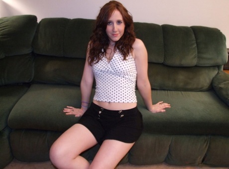 Natural redhead spreads her legs after getting naked on a sofa ensemble