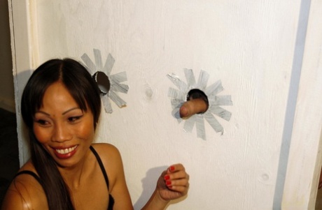 Den asiatiske tøs Filipino Faye sutter sperm fra flere pikke i et gloryhole