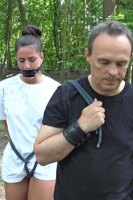 Jonge brunette slavin wordt gedisciplineerd en geneukt in het bos door haar Meester