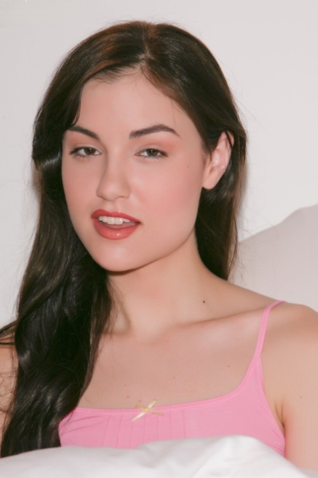 Die brünette Sasha Grey hebt ihr rosa Hemd an, um winzige Titten und kleine Nippel zur Schau zu stellen