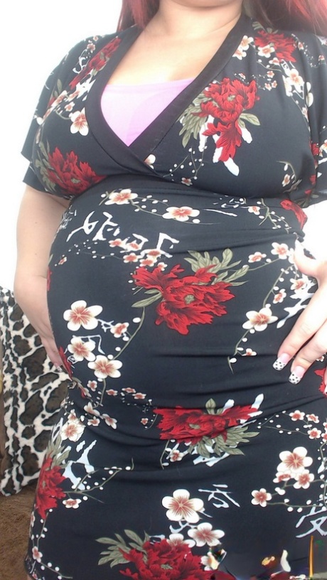 Zwangere roodharige Georgia Peach doet haar jurk uit en poseert naakt op de bank