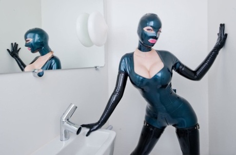 Lesbian women in latex catsuits and hoods partake in bathroom foreplay