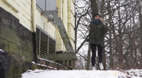 Wit meisje Masha toont haar blote kont terwijl ze pist op besneeuwde grond