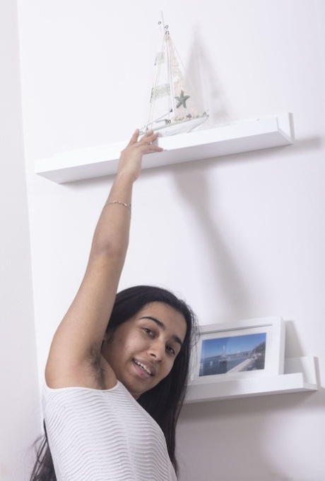 La hirsuta amateur Amira Roshane muestra el rosa de su coño encima de su cama