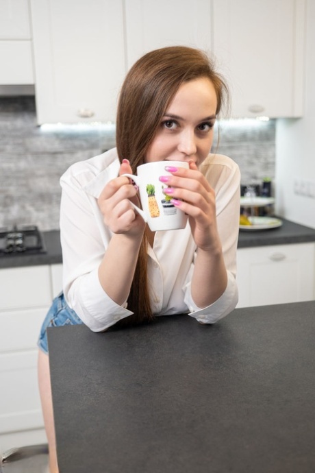 La giovane bellezza Jolie si spoglia completamente davanti a una tazza di caffè nella sua cucina