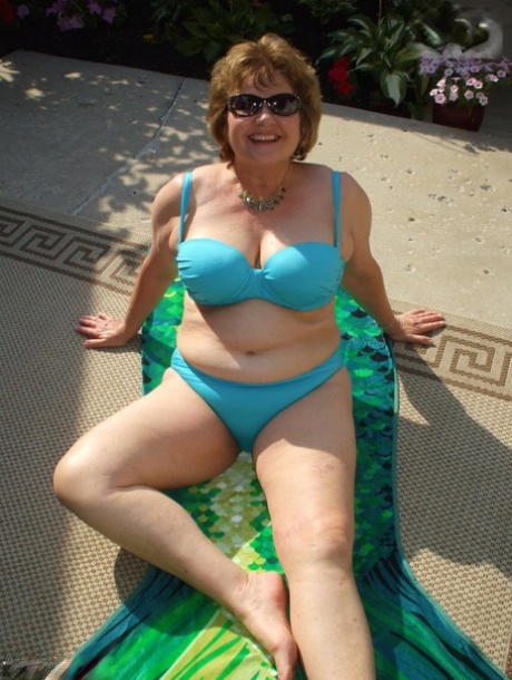 Oudere amateur Busty Bliss laat haar grote tieten los uit een bikinitopje in zonnebril