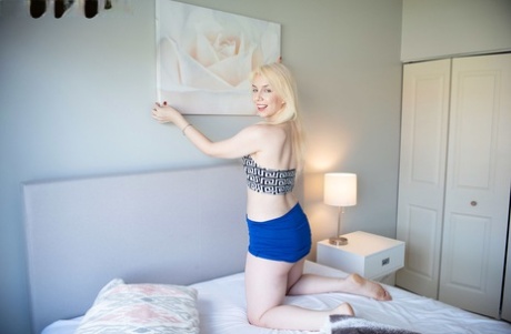 Mladá blondýnka Kimberly Vader si hraje se svými malými prsy na posteli v kalhotkách