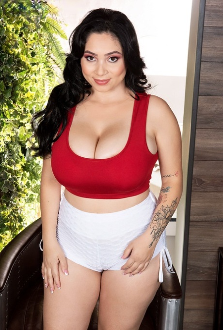 Thick Latina woman Kim Velez unleashes her big natural tits while disrobing