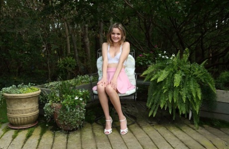 Teen cutie Addee Kate njuter av sin fitta på en stol ute på ett trädäck