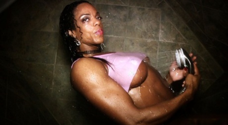 Ebony bodybuilder Alexis Ellis spant haar spieren tijdens het douchen