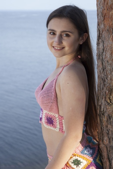 Die junge Sara zieht ihren Bikini aus, um in der Nähe des Ozeans nackt zu werden