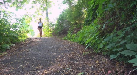 La petite fille Ali Bordeaux fait pipi en marchant sur un sentier dans les bois.