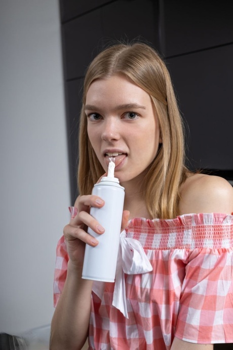 Den langbenede teenager Junia er helt nøgen, mens hun tilbereder sin morgenmad