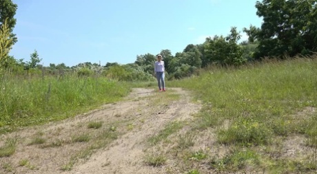 Caucasian girl Di Devi pulls down her pants to take a pee on a dirt road