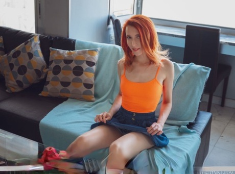 Junge Rothaarige Elin Flame strippt nackt auf einem Sofa in einer sexy Weise