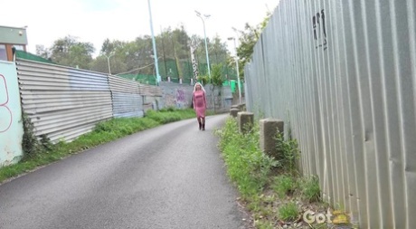 A loira tatuada Caroli levanta o vestido para urinar ao longo de uma estrada pavimentada