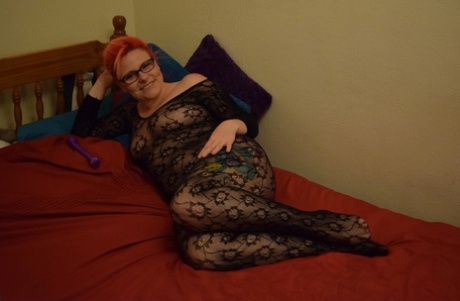 A amadora ruiva Mollie Foxxx masturba-se numa cama com um bodystocking sem entrepernas