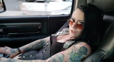 Getatoeëerde brunette Mallory Maneater masturbeert en pijpt in een auto