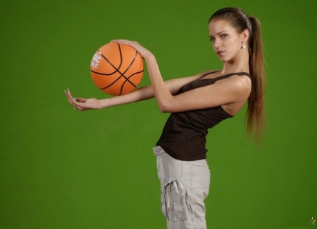 La fille solo Silvie Deluxe joue avec un ballon de basket tout en montrant ses seins fermes.