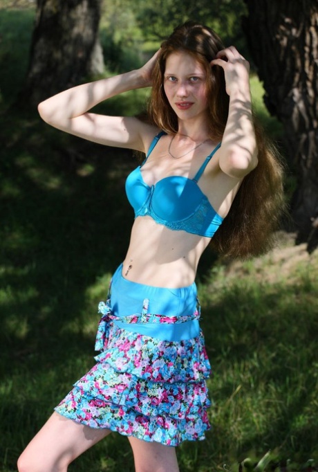 Barely legal girl Nicole exposes her slim body under a tree