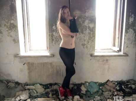 Martha, mannequin adolescente, déchire ses collants dans un bâtiment abandonné.