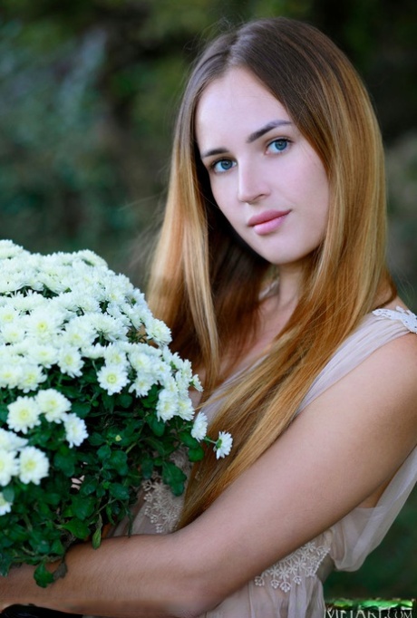 La giovane modella Hailey stringe un mazzo di fiori prima di spogliarsi all