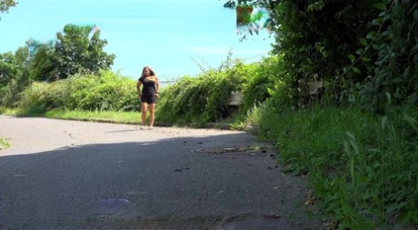 La blonde Jena Lovely fait pipi sur une route pendant la journée.