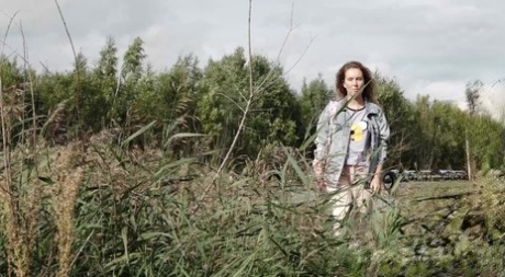 White girl Rita pulls down her sweats to take a pee next to some long weeds