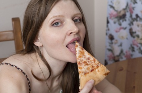 La amateur Milasha se come una porción de pizza antes de mostrar su culo y su coño