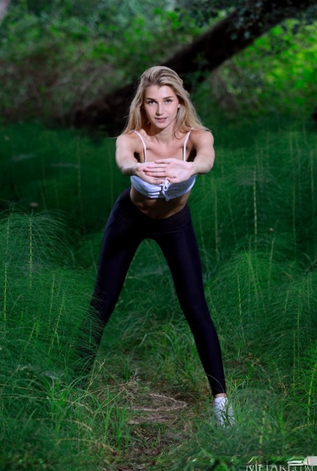 Подростковая модель Кристина Кардо снимает черные леггинсы, чтобы обнажиться среди папоротников