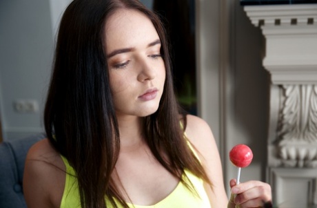 Jonge brunette Phonexia houdt een zuignap vast terwijl ze zich helemaal uitkleedt