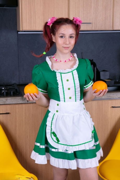 Young redhead Lexi gets totally naked while making orange juice