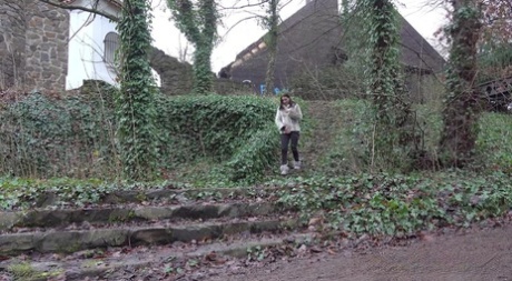 La niña blanca Victoria Daniels orina junto a un camino con botas de invierno y abrigo