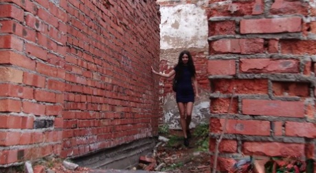 Kaukasisch meisje Katya toont haar lekkere kontje terwijl ze pissen in de buurt van bakstenen muren