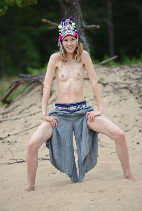 Skinny young girl Shanty A gets totally naked on driftwood at the beach