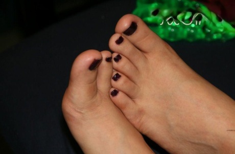 Caucasian girl dons toe spreaders before painting her toenails