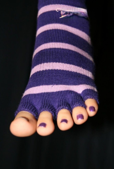 Mujer caucásica muestra sus uñas pintadas en calcetines sin dedos