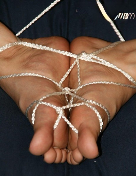 Caucasian female has her bare feet tied together with cord